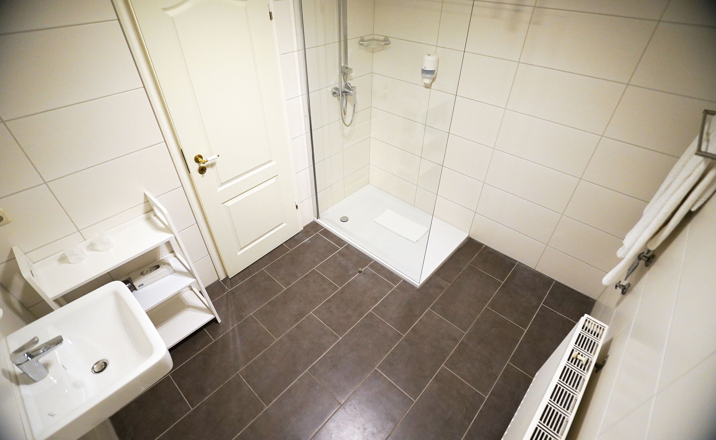 A bathroom with a shower, a sink, and a toilet.