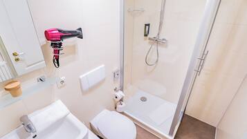 A bathroom with a sink, toilet, and shower.