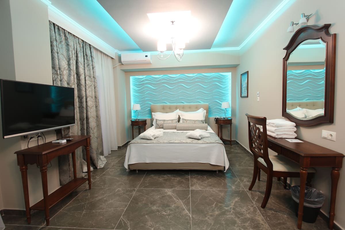 A hotel room with a bed, a TV, a desk, and a chair.