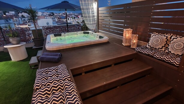 A rooftop terrace with a hot tub, seating area, and decorative elements. - Hotel Mallas (Nea Propontida)