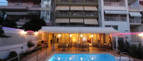 Alberca al aire libre, sombrillas en la alberca y camastros