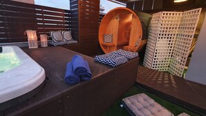 A spa area with a hot tub, wooden seating, and a wooden sauna. - Hotel Mallas (Nea Propontida)
