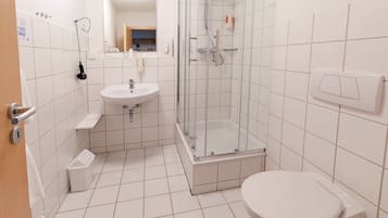 A modern bathroom with a glass-enclosed shower, a sink, and a toilet.