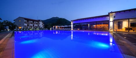 Una piscina al aire libre de temporada, sombrillas