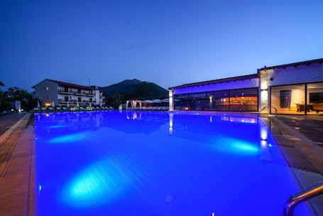 Una piscina al aire libre de temporada, sombrillas