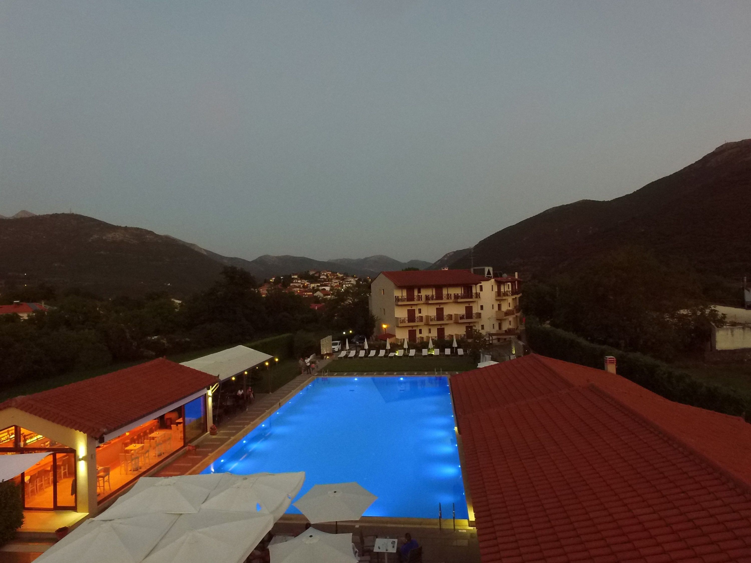 A swimming pool with a red-roofed building in the background.