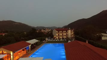 A swimming pool with a red-roofed building in the background.