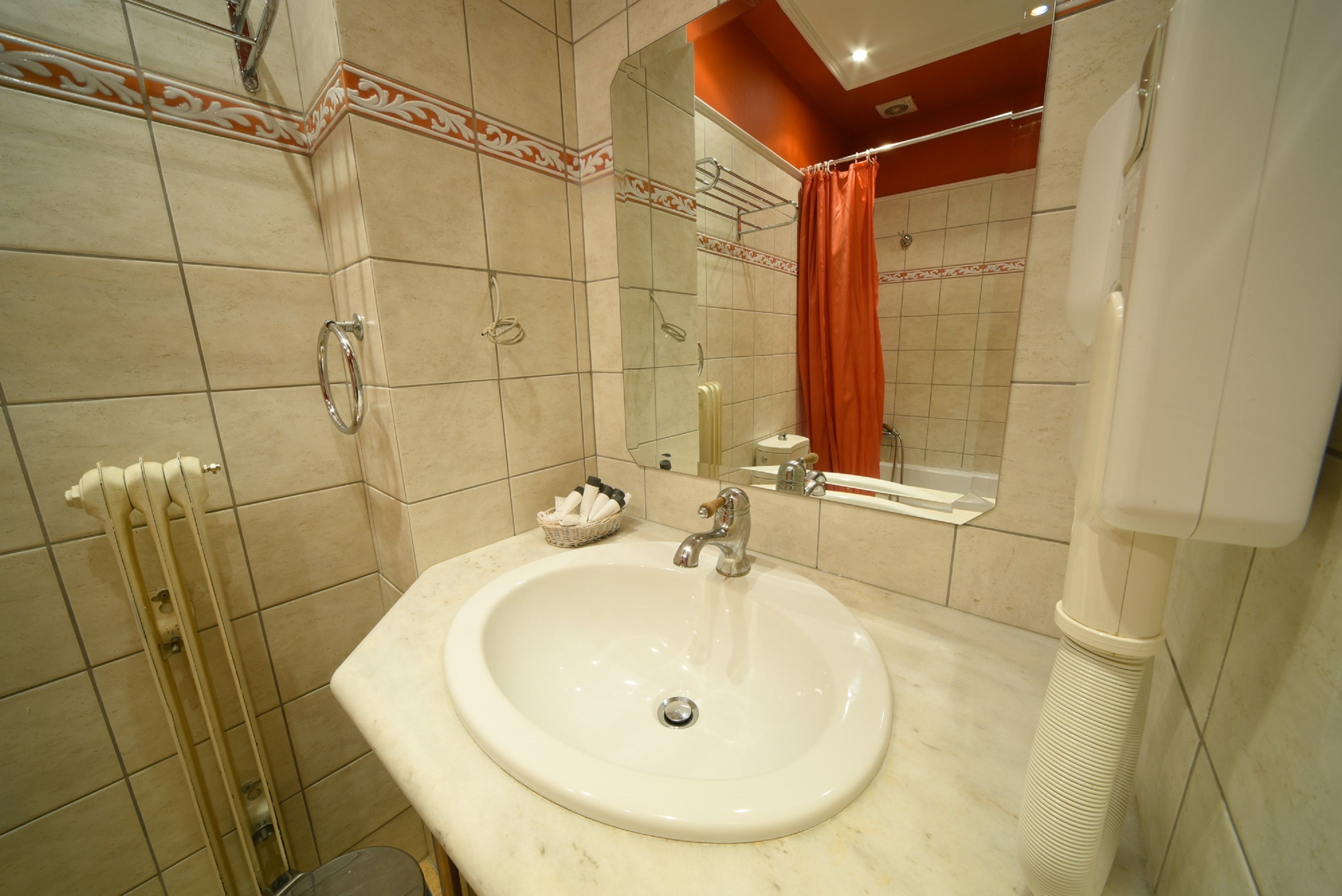 A bathroom with a white sink, a mirror, and a shower curtain.