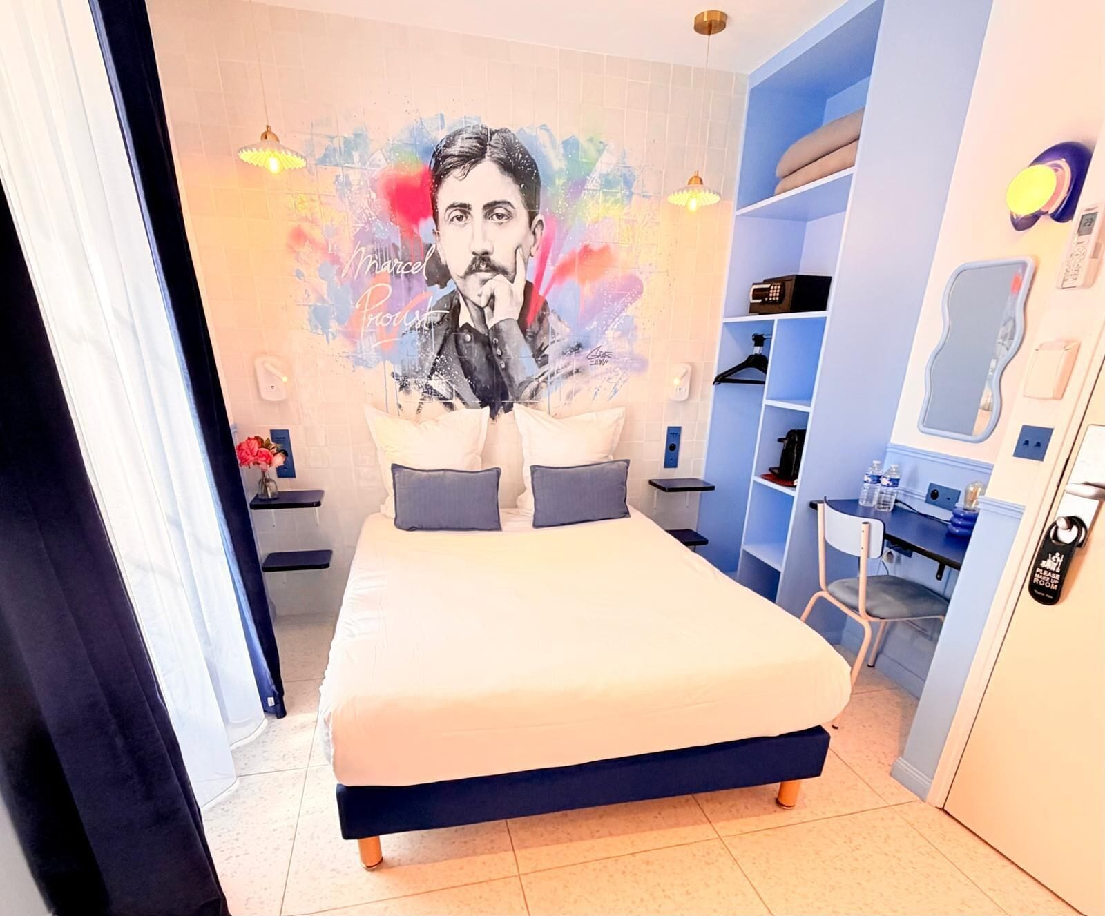Un dormitorio con una cama, un mural en la pared, un escritorio y una silla.