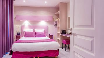 A bedroom with a large bed, a desk, and a chair.