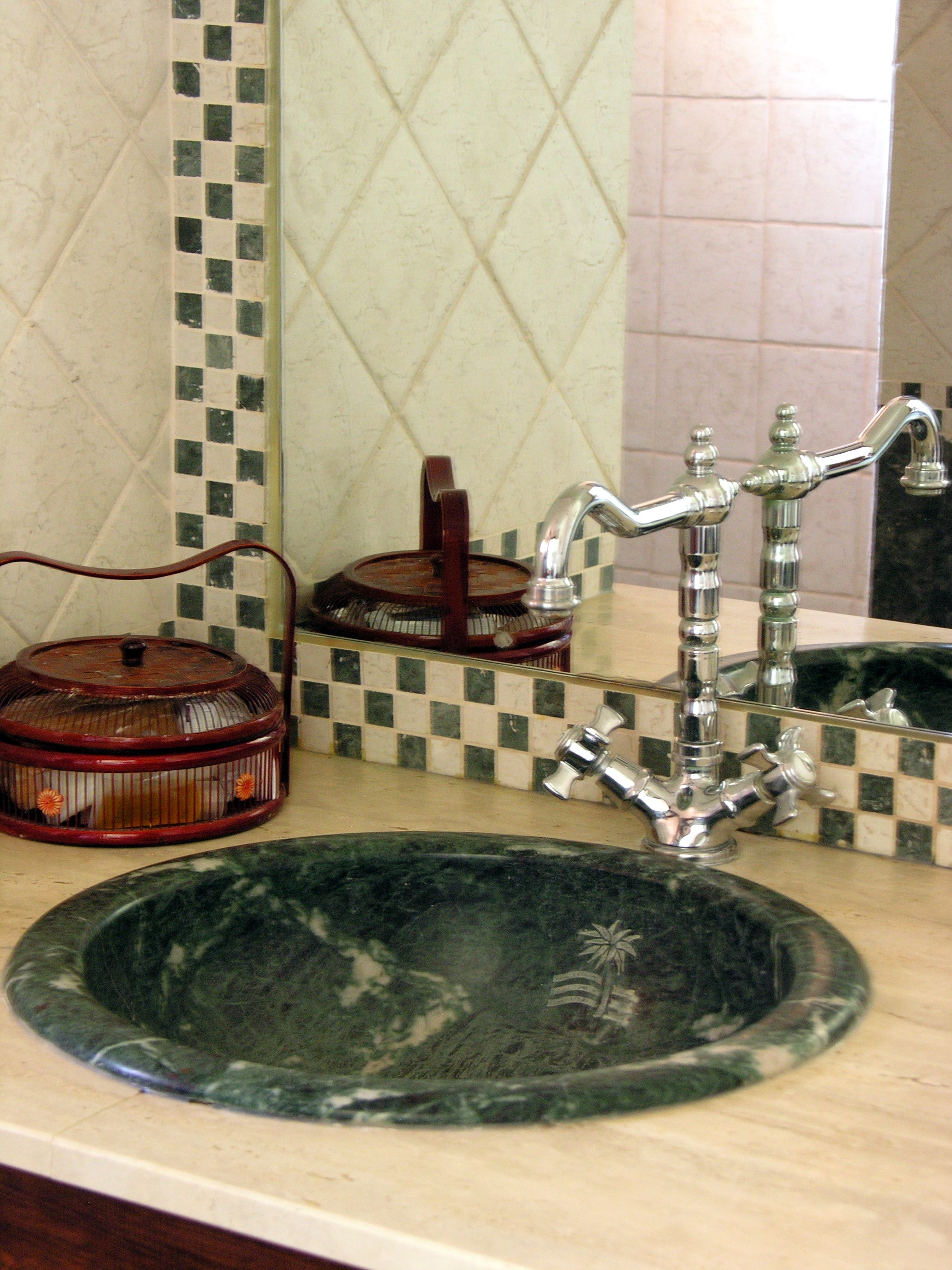 A bathroom with a sink, a mirror, and a tiled backsplash.