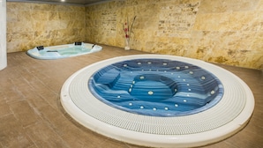 A spa area with two hot tubs and a stone wall. - Hotel de Naturaleza Rodalquilar Spa Cabo de Gata (Nijar)