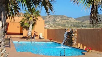 Alberca al aire libre y camastros