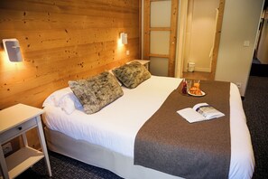 Relax in a serene space with a large bed, nightstand, and a small table.