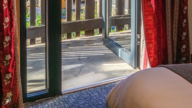 A room with a large window, a wooden balcony, and a view of snow-capped mountains. - Le Faranchin (Villar-d'Arene)
