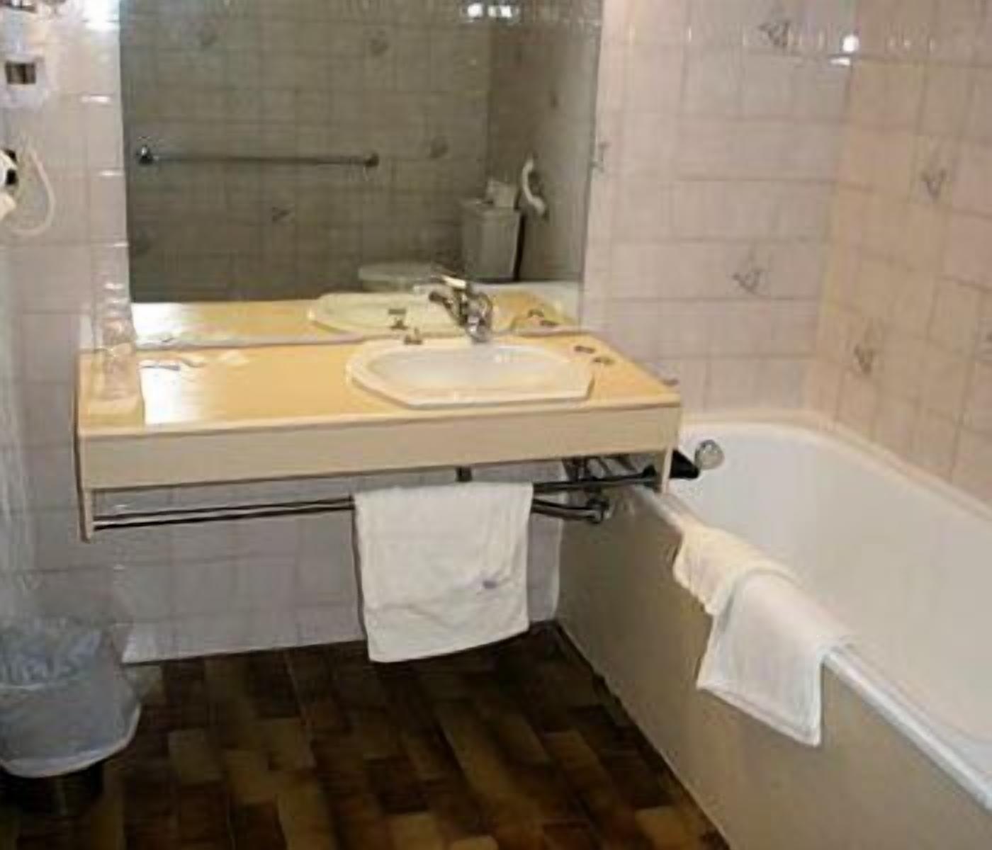 Un baño con lavabo, espejo y bañera.