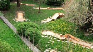 A landscaped garden with a wooden slide and a small pond. - Hôtel Le Carina (Gap)
