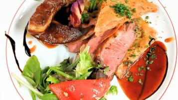 A plate of food with various meats, vegetables, and a sauce.