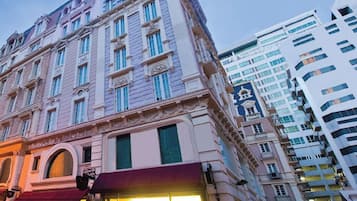 A historic building with classical architecture, large windows, and a ground-floor shop.