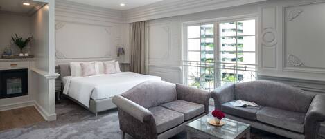 Ein Hotelzimmer mit einem Bett, zwei Sofas, einem Couchtisch und Blick auf die Stadt.