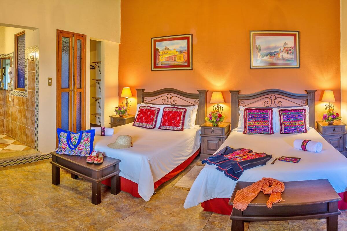 Une chambre d’hôtel avec deux lits, une salle de bain et un coin repas.