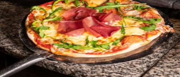 Una pizza con diferentes ingredientes sobre una bandeja.