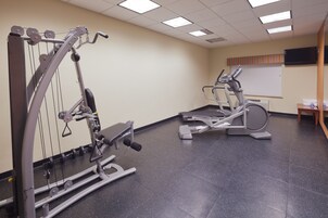 A gym with cardio machines, weight machines, and a treadmill.