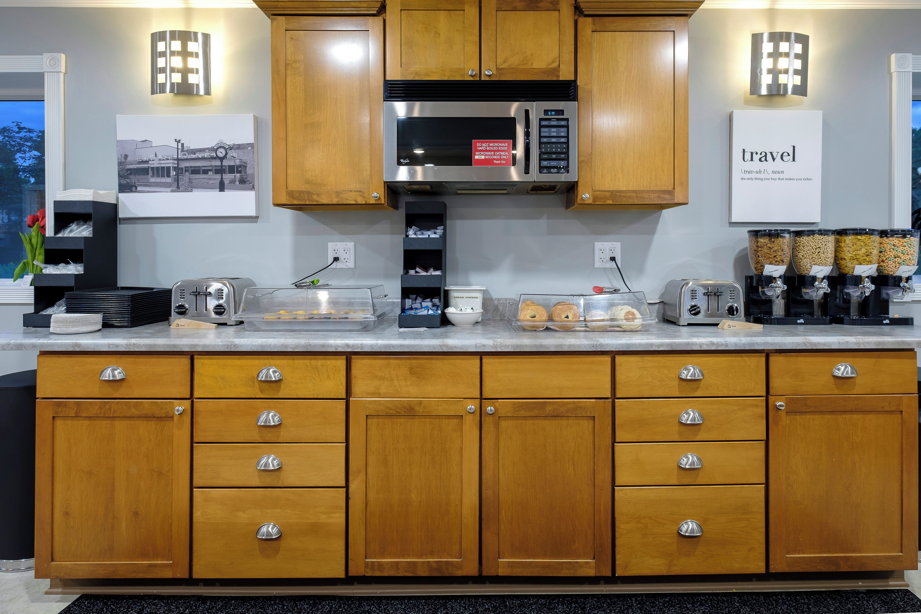 Una cocina moderna con armarios de madera, electrodomésticos de acero inoxidable y una encimera con diversos objetos.