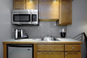 A compact kitchen with a built-in microwave, a coffee maker, and a sink. - Red Roof Inn & Suites Herkimer (Herkimer)