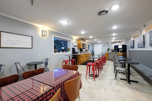 A restaurant with a bar area, tables, and chairs. - Red Roof Inn & Suites Herkimer (Herkimer)