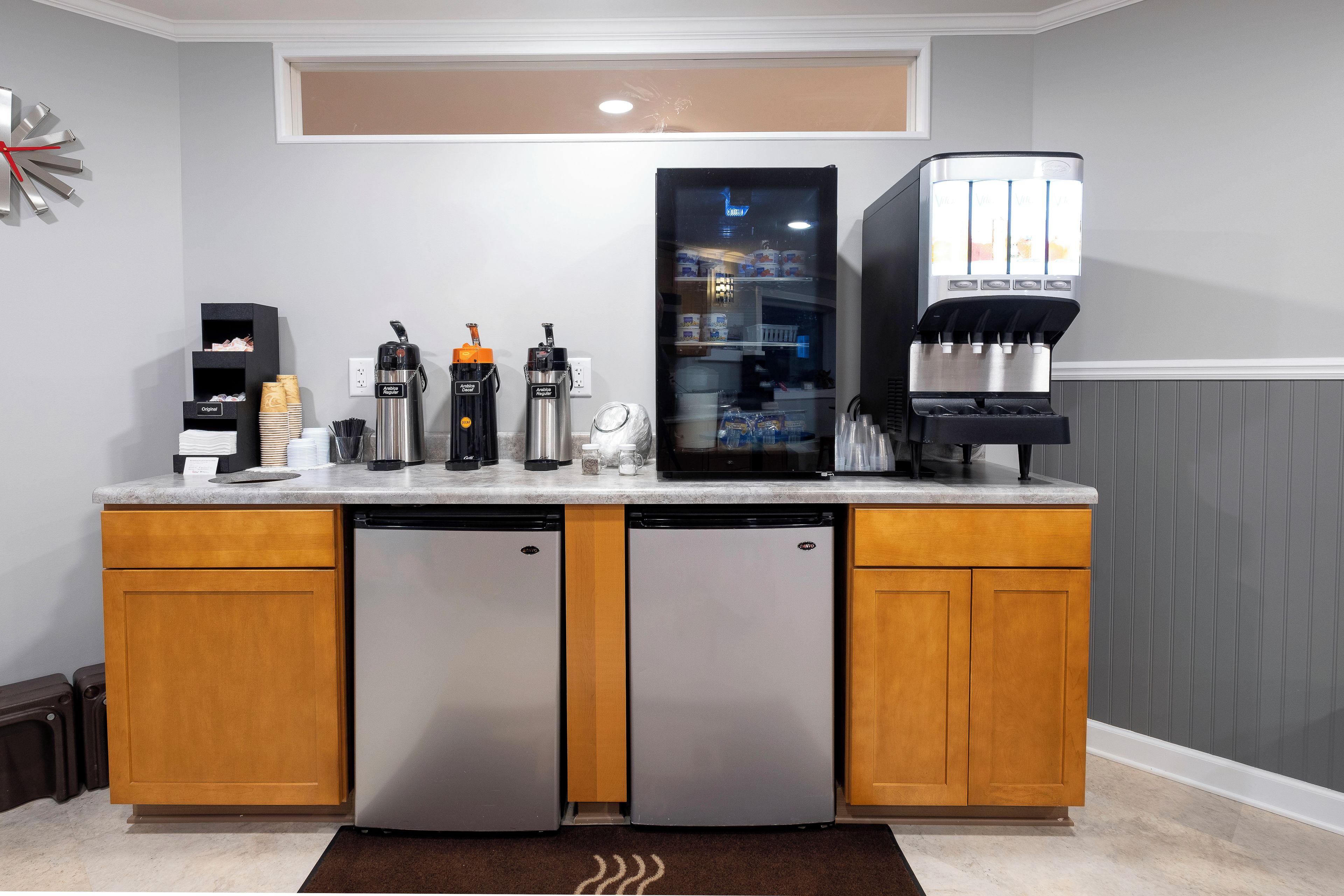 A compact kitchenette with a coffee machine, a water dispenser, and a refrigerator.