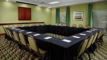 A conference room with a long table, chairs, and a cabinet.
