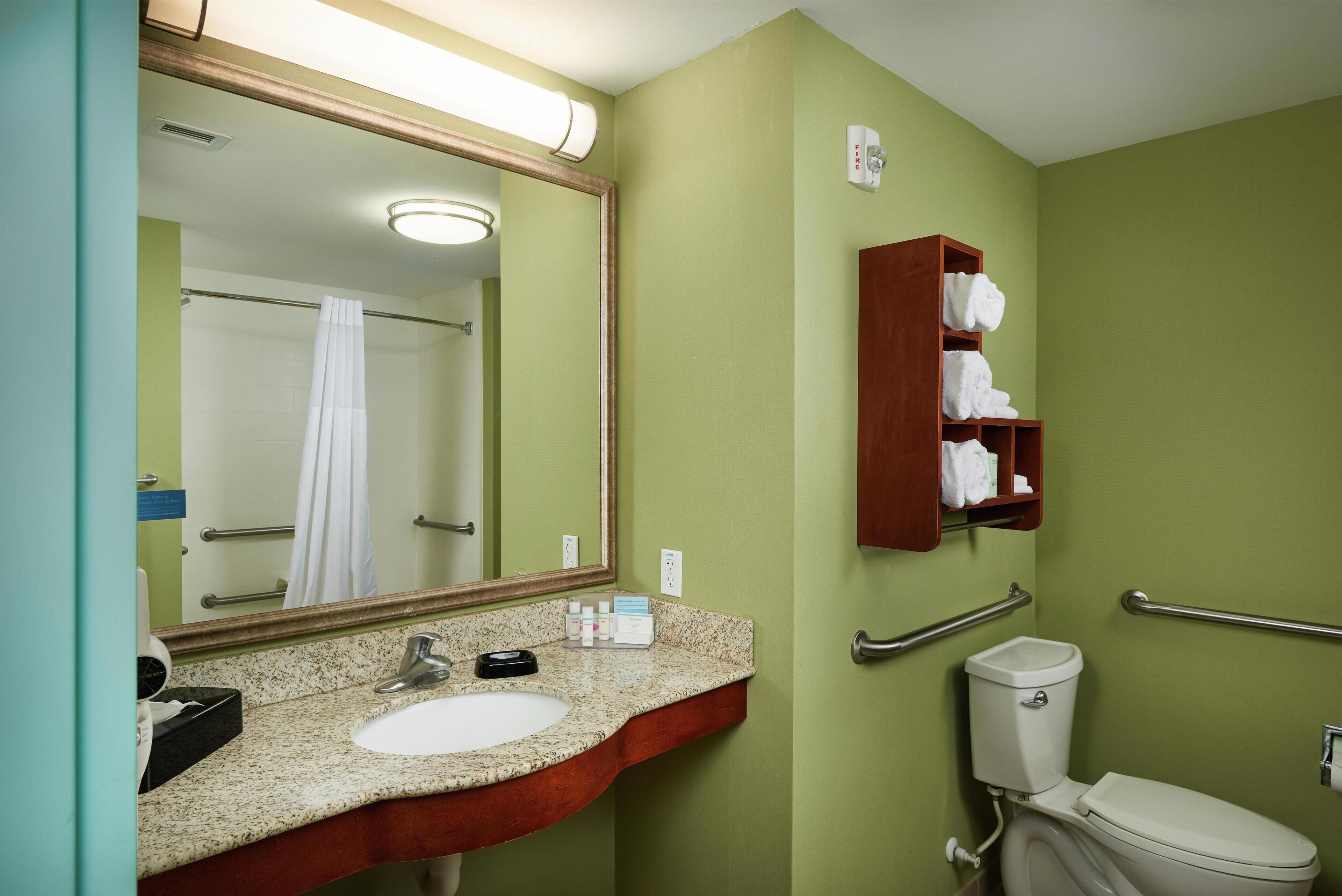 A bathroom with a sink, mirror, towel rack, and toilet.