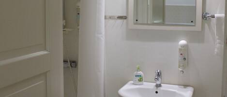 A bathroom with a white sink, a mirror, and a shower curtain.