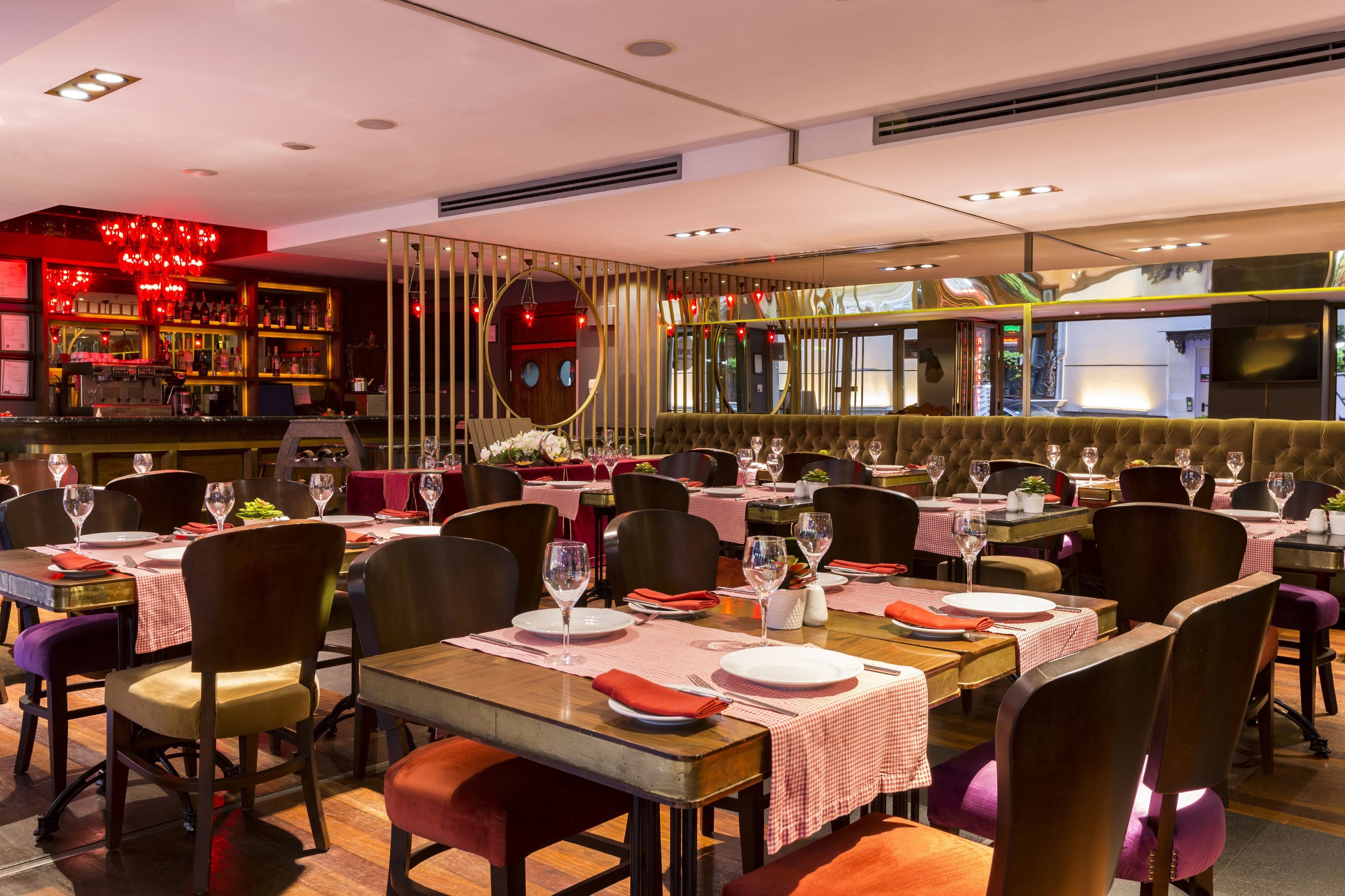 A restaurant with multiple dining tables, chairs, and a bar area.