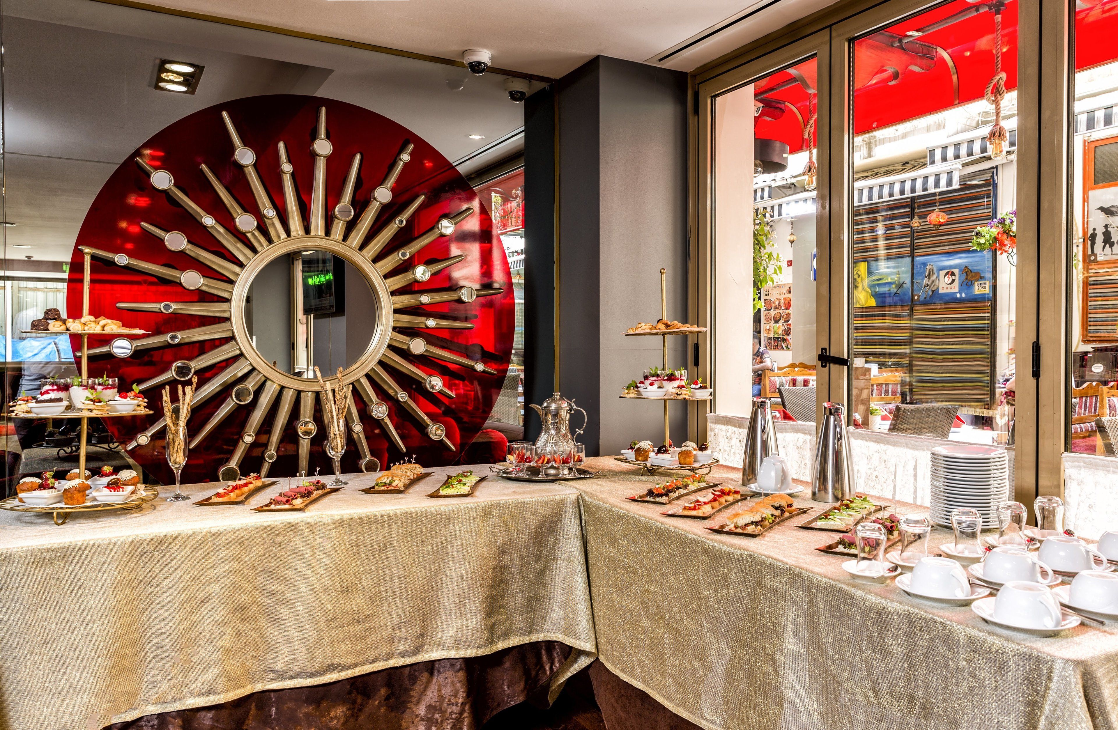 A dining area with a large decorative mirror, a variety of plated appetizers, and a well-organized table setting.
