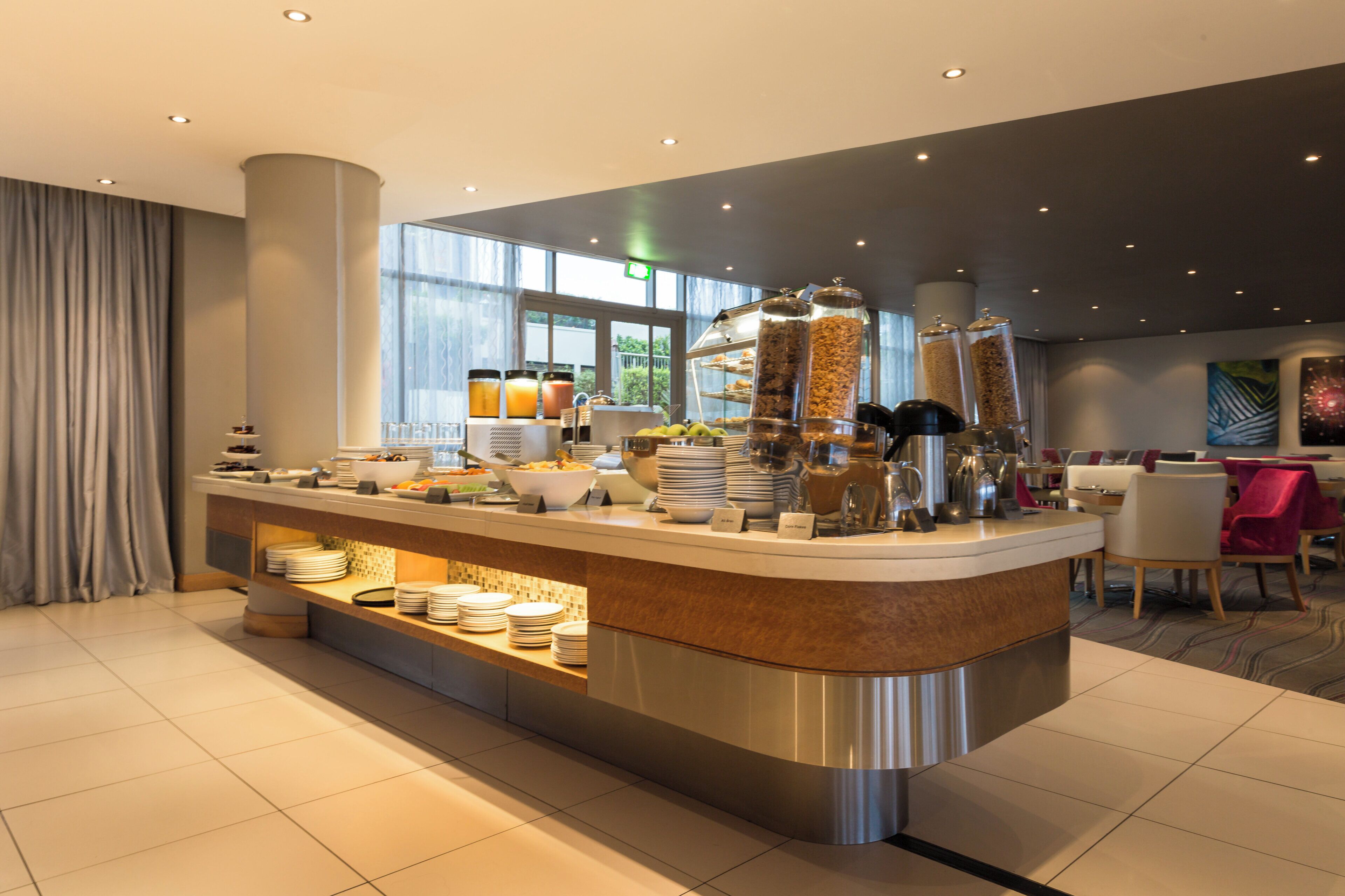 Una barra de desayuno moderna con una variedad de alimentos y una estación de café.