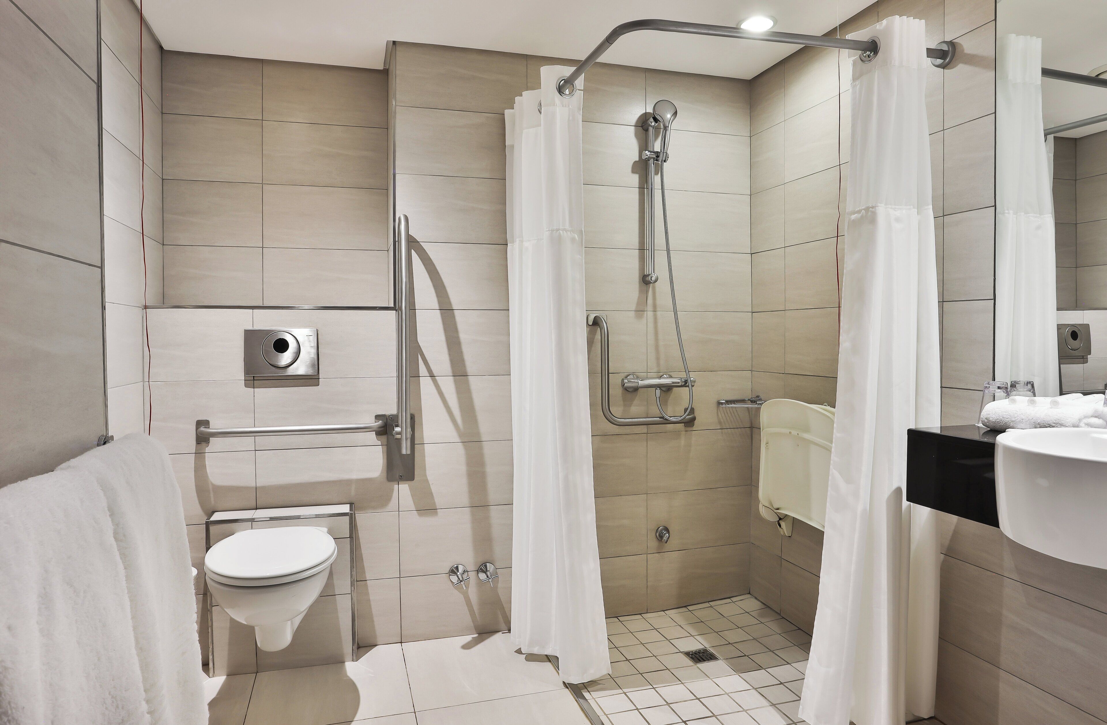A modern bathroom with a shower, toilet, and sink.