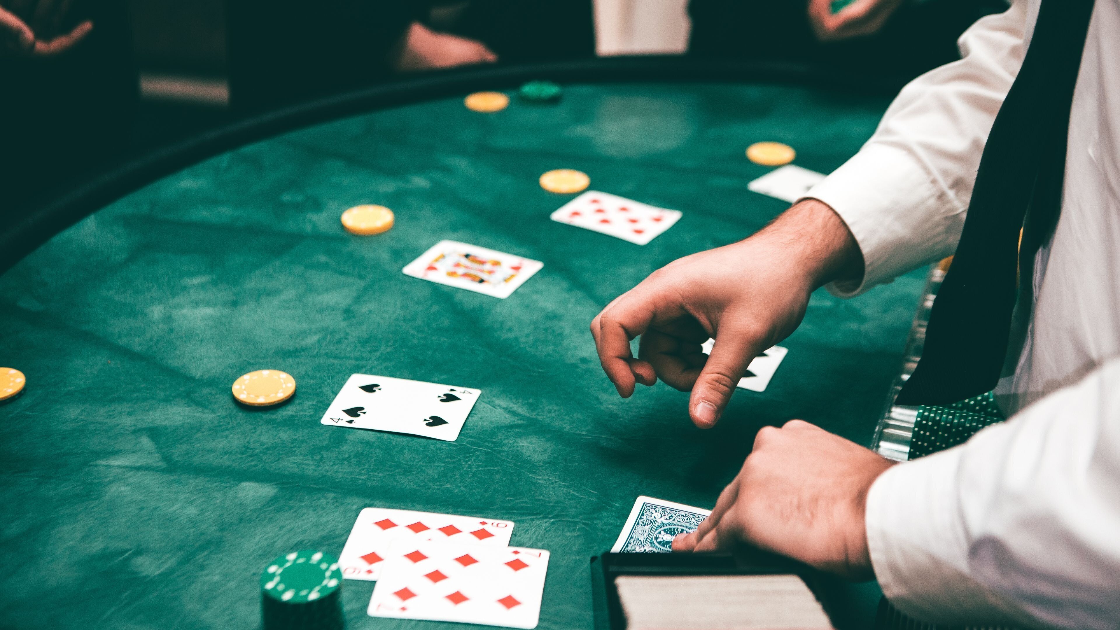 A green felt table with playing cards and poker chips.