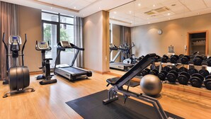 A gym with treadmills, elliptical machines, a weight bench, and a rack of dumbbells. - Holiday Inn Express Durban - Umhlanga by IHG (Umhlanga)