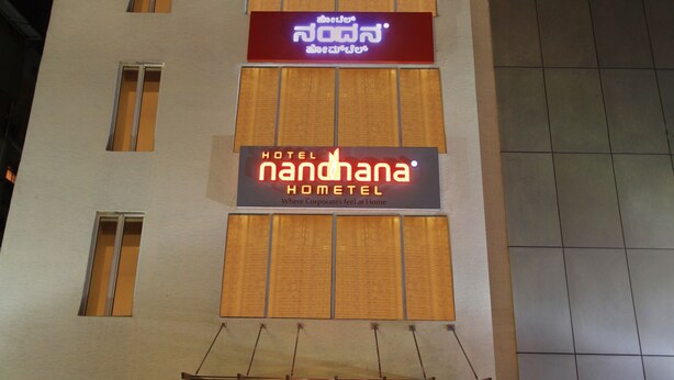 A hotel building with multiple windows and two prominent signs. - La Sara Hometel (Bengaluru)