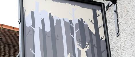 A sign for "The White Hart" pub with a forest silhouette and a chef's hat.