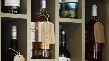 Una botellera con varias botellas de vino, cada una con etiqueta y un colgante.