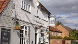 En traditionell pub som heter ”The White Hart”, med en skylt som visar att det finns möjlighet att äta här och att det finns rum att hyra.