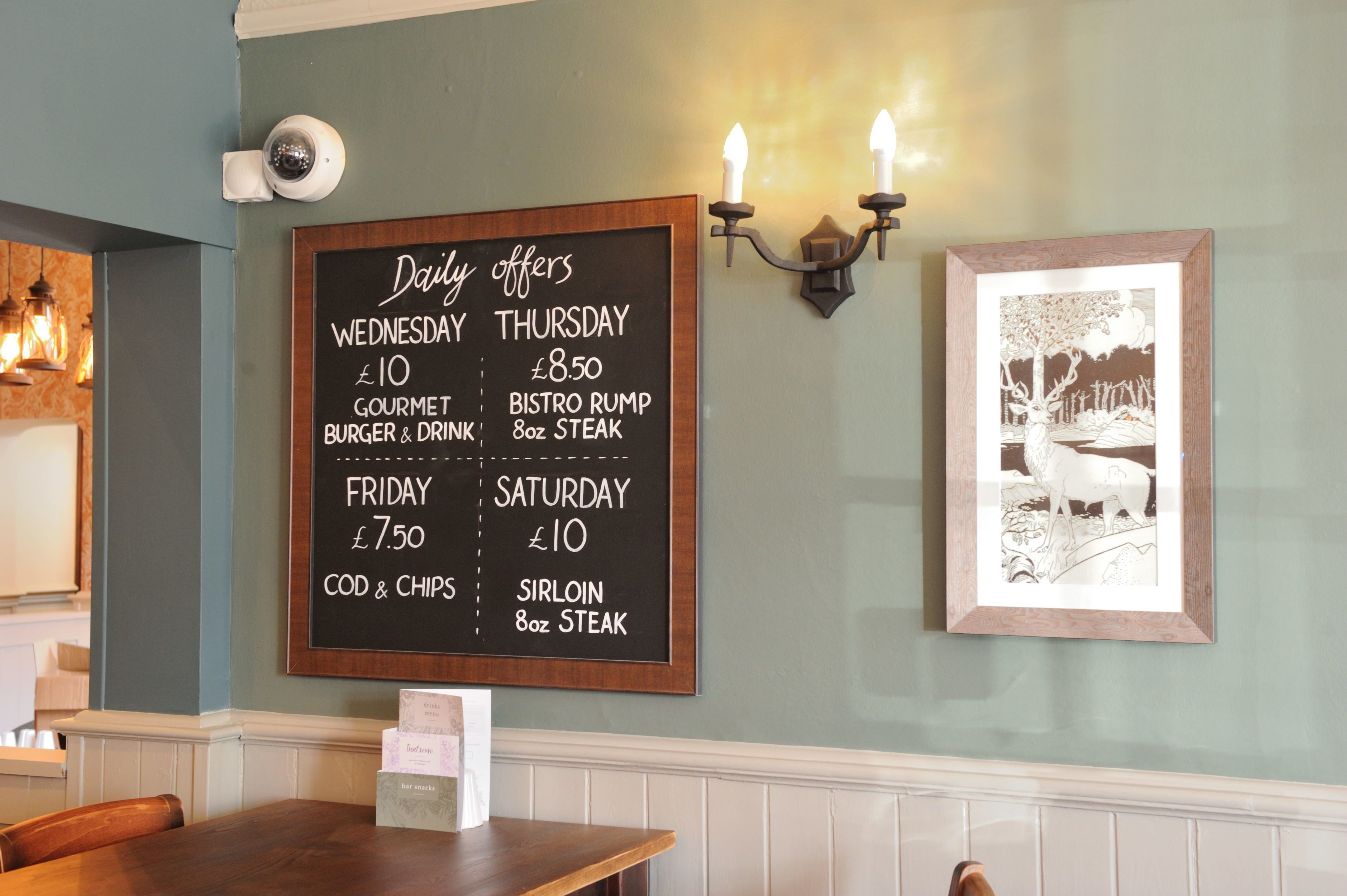 A restaurant menu board with daily offers for different days of the week.