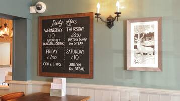 A restaurant menu board with daily offers for different days of the week.