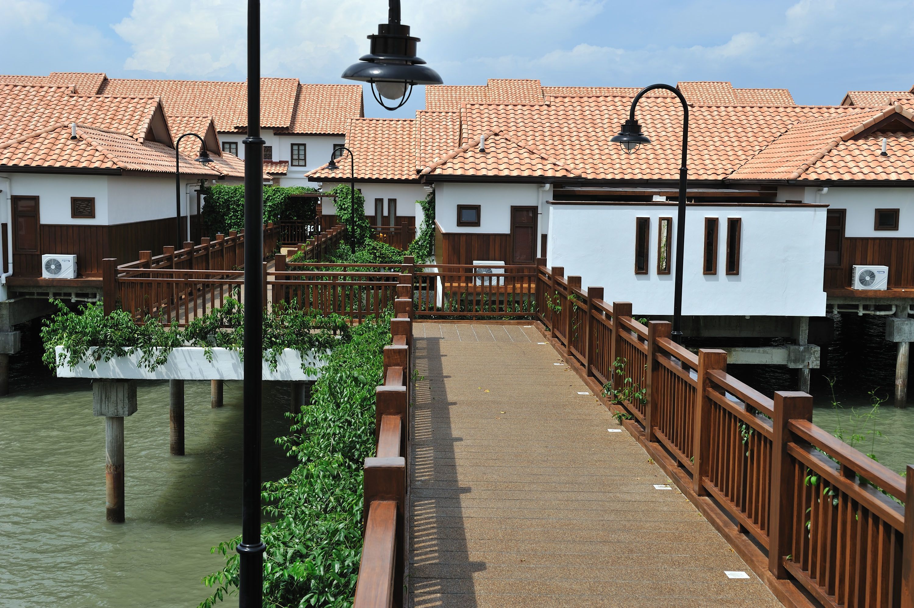 A wooden bridge over water with buildings on either side.