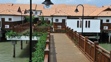 A wooden bridge over water with buildings on either side.