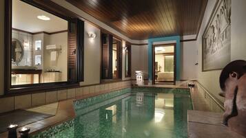 Relax by the serene indoor pool, surrounded by a warm atmosphere and elegant design.