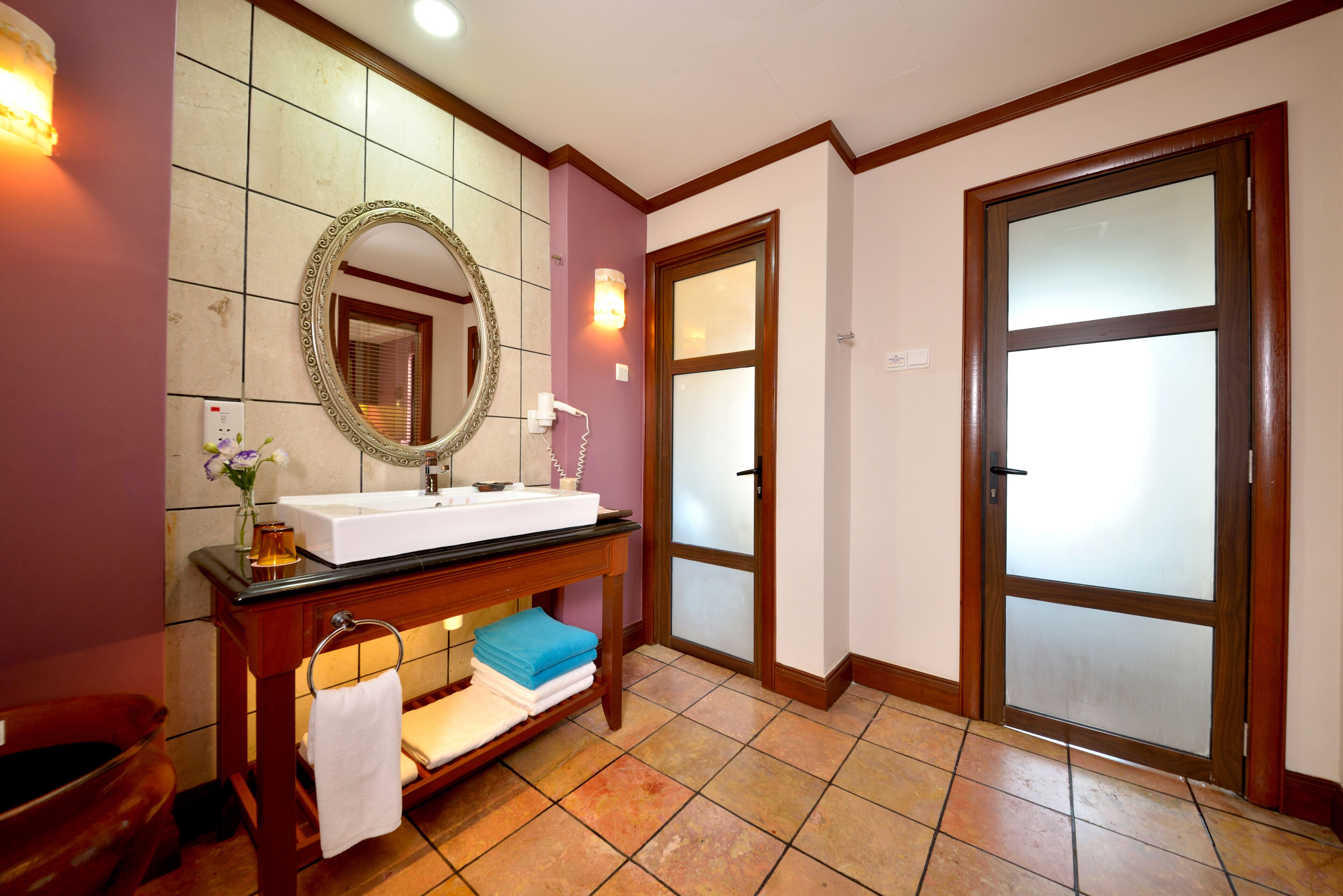 A bathroom with a vanity, mirror, and towel rack.